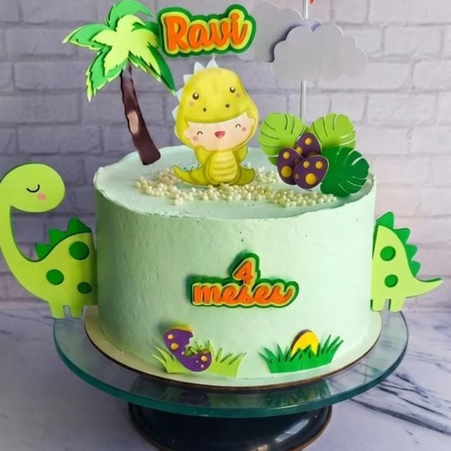Bolo verde com dinossauros e palmeiras de papel, topo do Ravi de 4 meses